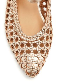 Chaussure de ballet en rose gold métallisé tissé avec un bout pointu, présentant des motifs découpés et une bride au niveau de la cheville pour un accent supplémentaire.