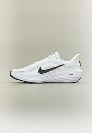Fehér Nike futócipő fekete swoosh logóval, légáteresztő hálós felsőrésszel és párnázott talppal, melyeken "ComfiRide" és "Air" felirat szerepel.