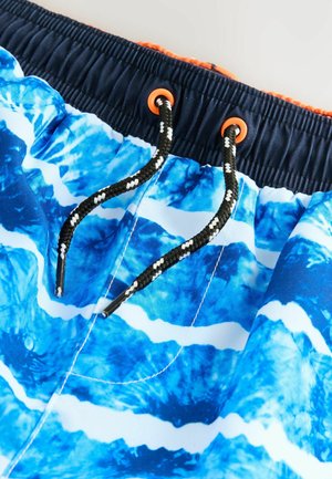 Blauwe zwembroek met golfpatronen, elastische tailleband, oranje oogjes en zwarte trekkoord met witte accenten. Glad, lichtgewicht stof.