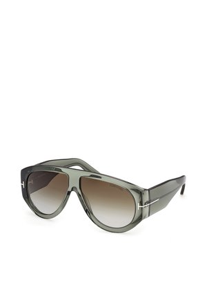 Oversized gray translucent sunglasses with gradient brown lenses and silver T-shaped logo on temples, angled on white background.