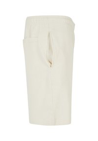 Shorts élastiques de couleur crème avec des poches latérales et arrière, présentés sous un angle latéral gauche sur fond blanc.