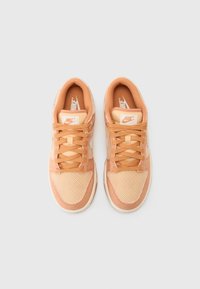 Sapatilhas Nike na cor pêssego, com um design em malha e texturizado, possuem atacadores, língua almofadada e detalhes com logotipo nas laterais e na língua.
