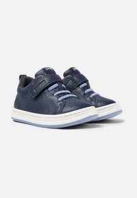 Sneakers in pelle blu navy con superficie testurizzata, suola intermedia bianca e lacci azzurri chiari. Presentano una fascia con chiusura a strappo e dettagli perforati.