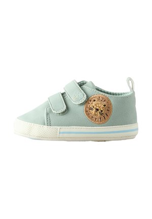 Light green toddler shoe with double velcro straps, white sole with blue stripes, and a stitched lion face on the side.