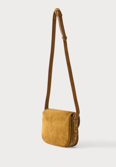 Μικρό τσαντάκι χιαστή από καστόρι σε χρώμα μουσταρδί, με ρυθμιζόμενο καφέ δερμάτινο λουράκι και αγκράφα και καρφιά σε χρυσό τόνο.