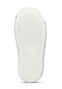 Sole di sneaker bianca con un motivo a onda, caratterizzata da un logo circolare con una 'N' e un accento numerato, che offre una presa testurizzata.