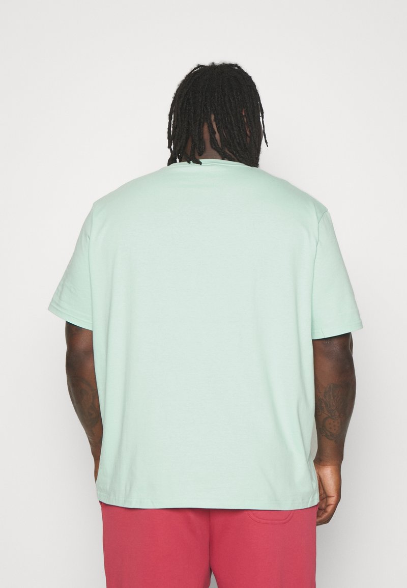 T-shirt in cotone verde menta con maniche corte e scollatura a girocollo, caratterizzato da una vestibilità rilassata e un orlo dritto in vita.