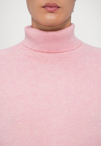 Maglione a collo alto rosa realizzato in morbido tessuto a maglia, con una silhouette aderente e una texture a coste attorno al colletto e all'orlo.