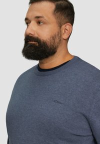 Blauwe gebreide sweatshirt met een ronde hals, voorzien van een textuurstof en een subtiele s.Oliver-logo geborduurd op de borst.