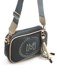 Kompakte graue Umhängetasche mit Reißverschluss, goldfarbenen Akzenten, hellbeigem Besatz und dekorativen, mehrfarbigen Quasten. Mit einem Logodesign versehen.