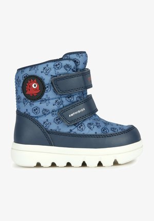 Bottes imperméables bleues avec des motifs de monstres, dotées de deux bandes Velcro réglables, d'un logo noir rond et d'une semelle en caoutchouc texturée.