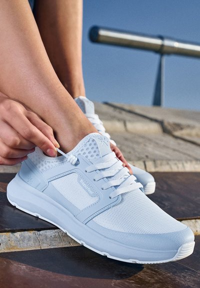Světle modrá sportovní obuv vyrobená z mikrovlákna a syntetického materiálu, s tkaničkami, polstrovaným jazykem a texturední podrážkou.