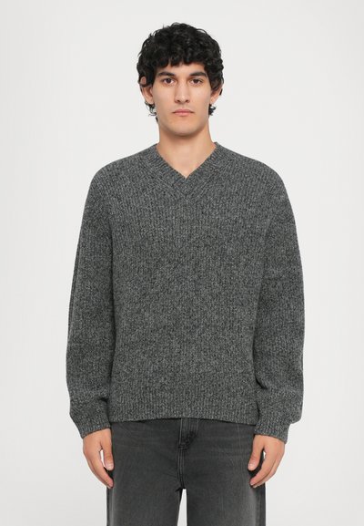 Pullover grigio lavorato a maglia con scollatura a V, maniche lunghe e orlo a costine. Realizzato in tessuto testurizzato, presenta un motivo sottile.