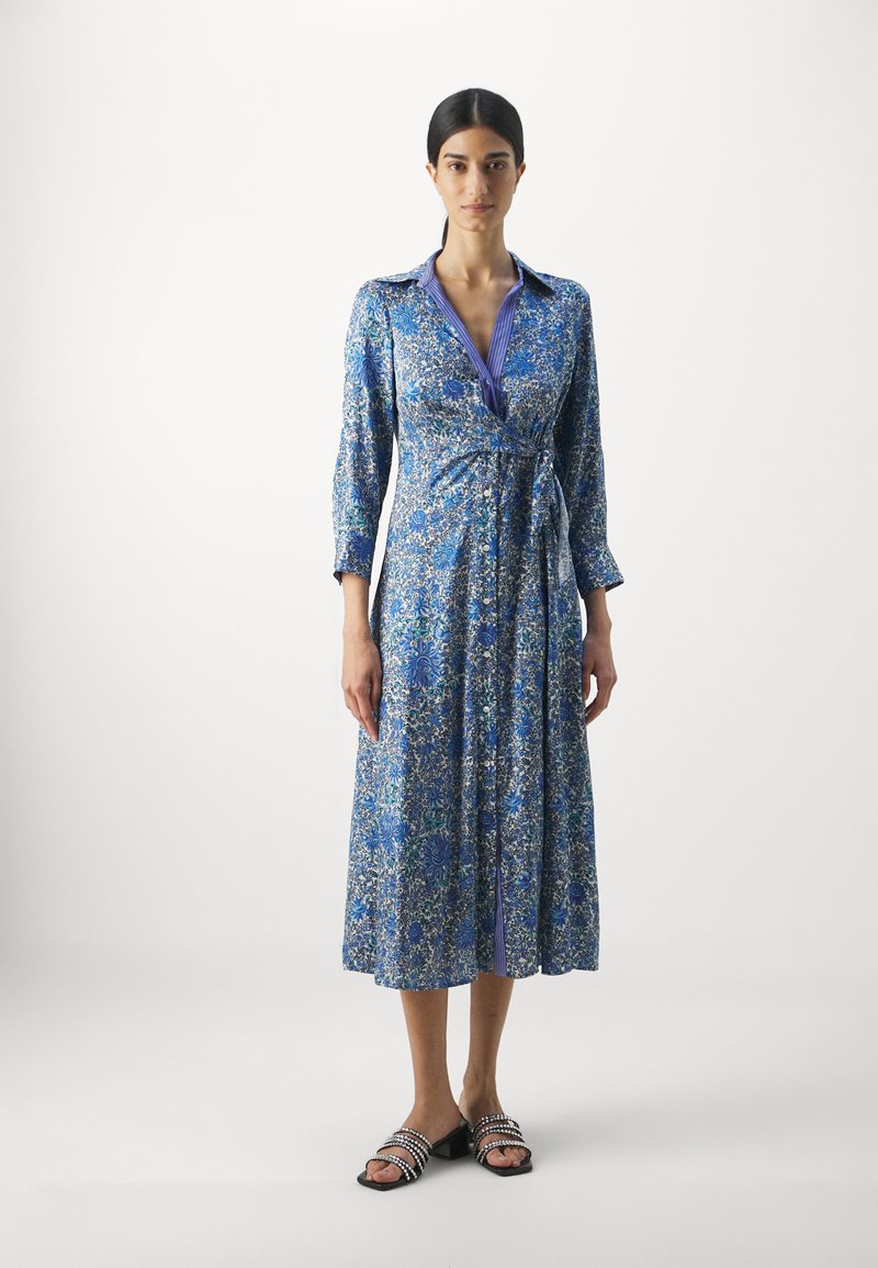 Blumen-Midikleid in Blautönen mit langen Ärmeln, einem Kragen, Knopfdetails und einem Bindegürtel. Das Muster umfasst kleine Blumen und Blätter.