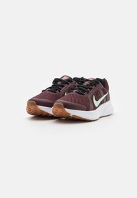 Baskets de sport bordeaux avec un dessus en mesh, lacets noirs, semelle intermédiaire blanche et semelle en gomme. Présente un design de swoosh en accent vert clair.