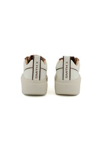 Sneaker bianche con colletto imbottito, caratterizzate da un accento marrone sul retro sopra "SMITH X". Suola spessa beige, tomaia in pelle liscia.