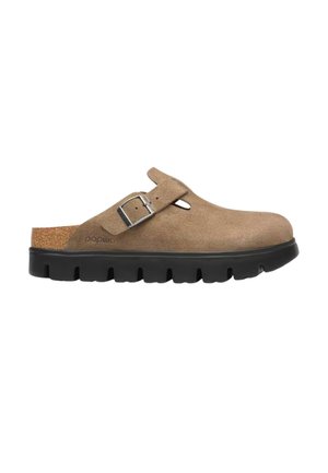 Scarpa slip-on in pelle scamosciata marrone con punta chiusa, suola nera spessa con battistrada e cinturino regolabile con fibbia sul collo del piede.