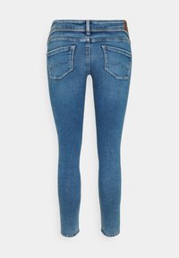 Jeans ajustados azules hechos de mezclilla, con una cintura alta, dos bolsillos traseros con costuras decorativas y una textura suave.