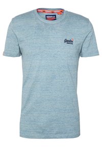 Camiseta de manga corta azul claro hecha de una tela texturizada. Presenta un pequeño logo en el pecho y un detalle en el cuello en contraste.