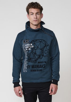 Sudadera azul marino con un patrón texturizado, que presenta un gráfico de calavera geométrica y texto en blanco. Cuello ajustable y puños negros.