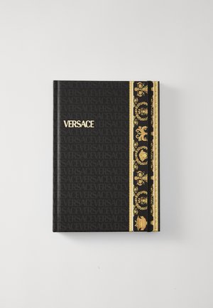 Versace spiralbundet notatbok. Svart omslag med gull-logo, utsmykket gyllent mønster og gjentagende "Versace"-tekst i bakgrunnen. Myk tekstur.