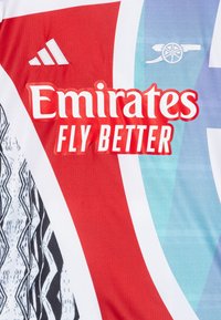 Fotballsdrakt med røde, hvite og lyseblå farger, med et teksturert mønster på siden, Adidas-logo og teksten "Emirates Fly Better".