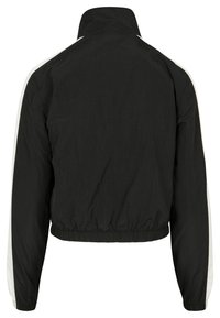 Jachetă neagră cu glugă, cu guler înalt, talie elastică și dungi albe pe laturile mânecilor lungi. Textură netedă, design lejer.