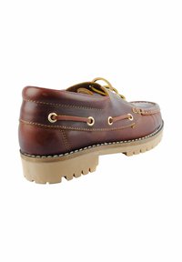 Zapato de barco de cuero marrón con detalles de costura, ojales en tono dorado y una suela de goma resistente. Incluye diseño de cordones y tacón bajo.