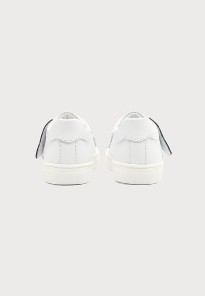 Paire de baskets blanches vues de dos avec un onglet gris au talon, sur un fond uni gris clair.