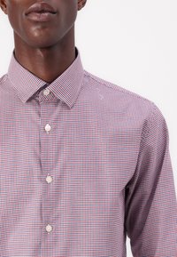 Men's button-up shirt in red, white, and blue check pattern; features a spread collar and pearlescent buttons; cotton fabric.