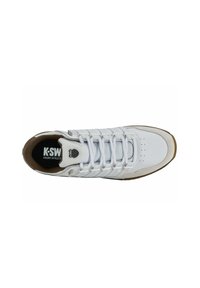Sneaker bianca con una toma superiore testurizzata, accenti grigi e una suola in gomma marrone. Presenta molteplici occhielli e un logo sulla linguetta.