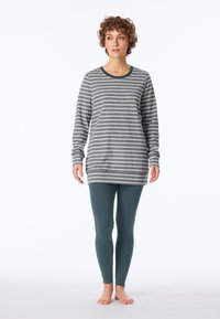 Grå och vit randig långärmad topp med rund halsringning, kombinerad med teal leggings. Mjuk tyg med en avslappnad passform.