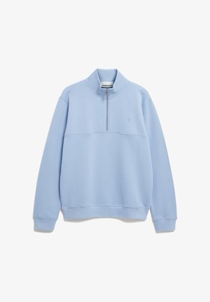 Lichtblauwe pullover met lange mouwen, halfrits aan de voorkant, hoge kraag en een subtiel logo op de borst, plat uitgespreid op een witte achtergrond.