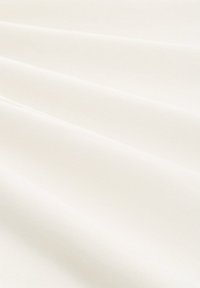 Tessuto bianco con una superficie liscia, che mostra morbide pieghe e una leggera lucentezza, adatto per abbigliamento o tappezzeria. Nessun motivo o accento visibile.