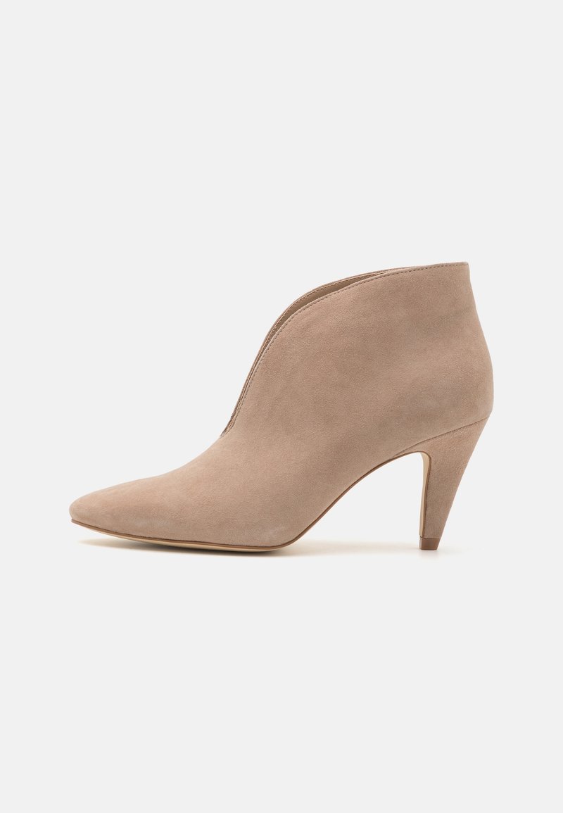 Bottine femme en daim beige avec bout pointu et talon conique de hauteur moyenne sur fond blanc uni.
