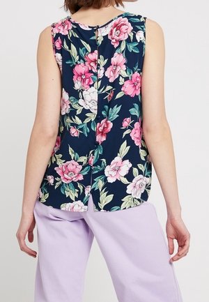 Marineblomstret ærmeløs top med store pink og hvide blomstermønstre, der har en rund halsudskæring og en knaplukning på ryggen.