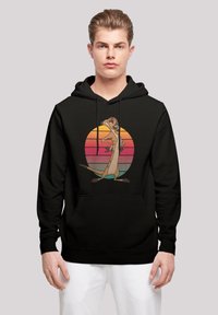 Felpa nera con cappuccio che presenta un personaggio dei cartoni animati con un'espressione giocosa, davanti a un cerchio con un gradiente di tramonto in toni di arancione e rosa.