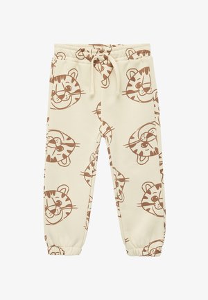 Pantalon de survêtement couleur crème avec un motif répété de têtes de tigre brunes, taille élastique avec cordon de serrage et bas de jambes fuselés.