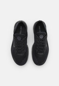 Schwarze Sportschuhe mit einem Obermaterial aus Mesh, dicken Schnürsenkeln und strukturiertem Profil. Verfügt über ein dezentes Logo auf der Zunge und ist für Atmungsaktivität ausgelegt.