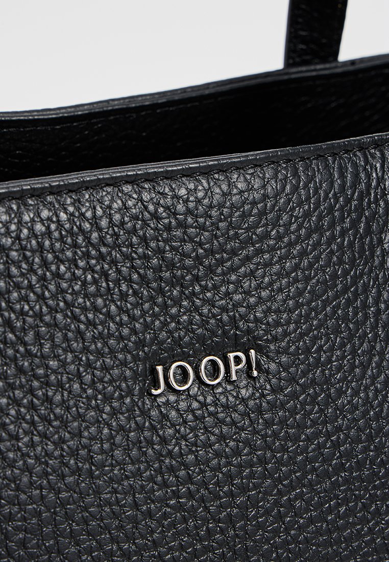 Schwarze strukturierte Ledertasche mit silbernen Metalbuchstaben, die "JOOP!" auf der Vorderseite bilden.
