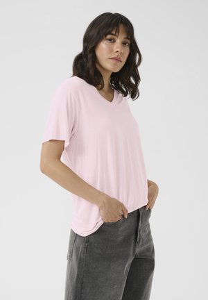Lyserød V-hals t-shirt med korte ærmer, blødt stof, afslappet pasform, parret med mørkegrå højtaljede bukser med lommer i side sømmene.