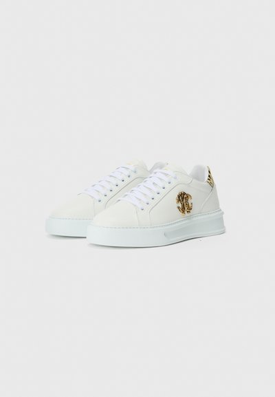 Adidași din piele albă cu o suprafață texturată, detalii cu logo auriu pe lateral și sireturi albe. Caracteristici includ o talpă groasă din cauciuc și un design minimalistic.