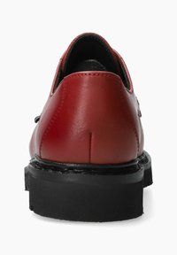 Chaussures en cuir rouge avec une texture lisse, bout rond, semelle en caoutchouc noir et accents cousus à l'arrière et sur les côtés.