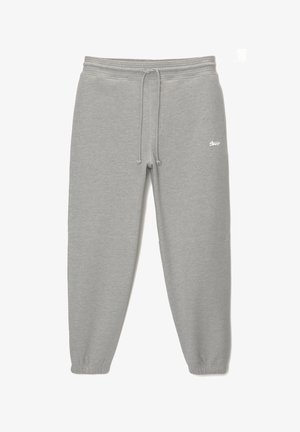 Pantalons de survêtement gris avec taille élastique et cordon de serrage. Présente des jambes fuselées et un accent logo sur le devant. Texture de tissu douce.