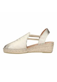 Metalen zilveren espadrille met een sleehak, voorzien van een getextureerde leren bovenkant en elastische banden voor ondersteuning. Gevlochten jute zool.