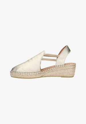 Metallic silver espadrille with a wedge heel, featuring a textured leather upper and elastic straps for support. Braided jute outsole.