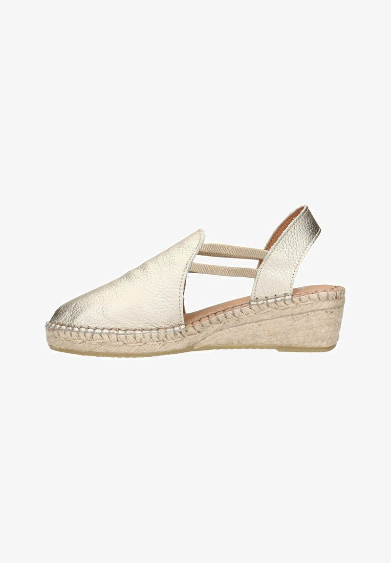 Metallic silver espadrille with a wedge heel, featuring a textured leather upper and elastic straps for support. Braided jute outsole.