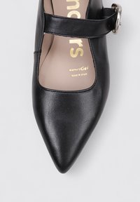 Zapato negro de cuero estilo Mary Jane con punta afilada, correa ajustable y detalles en plata. Plantilla acolchada con la marca "memoryGel".