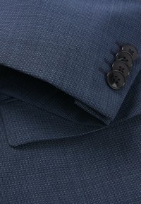 Dunkelblau strukturierter Stoff mit einem dezenten Muster, ausgestattet mit einem umgeschlagenen Ärmelsaum und vier schwarzen Knöpfen mit glatter Oberfläche.