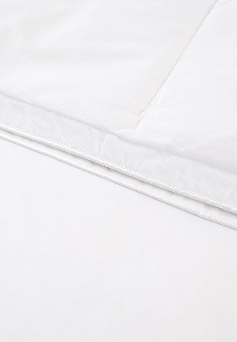 Biancheria da letto bianca con una superficie liscia e testurizzata, caratterizzata da una leggera lucentezza. I bordi sono cuciti in modo ordinato con un design semplice.